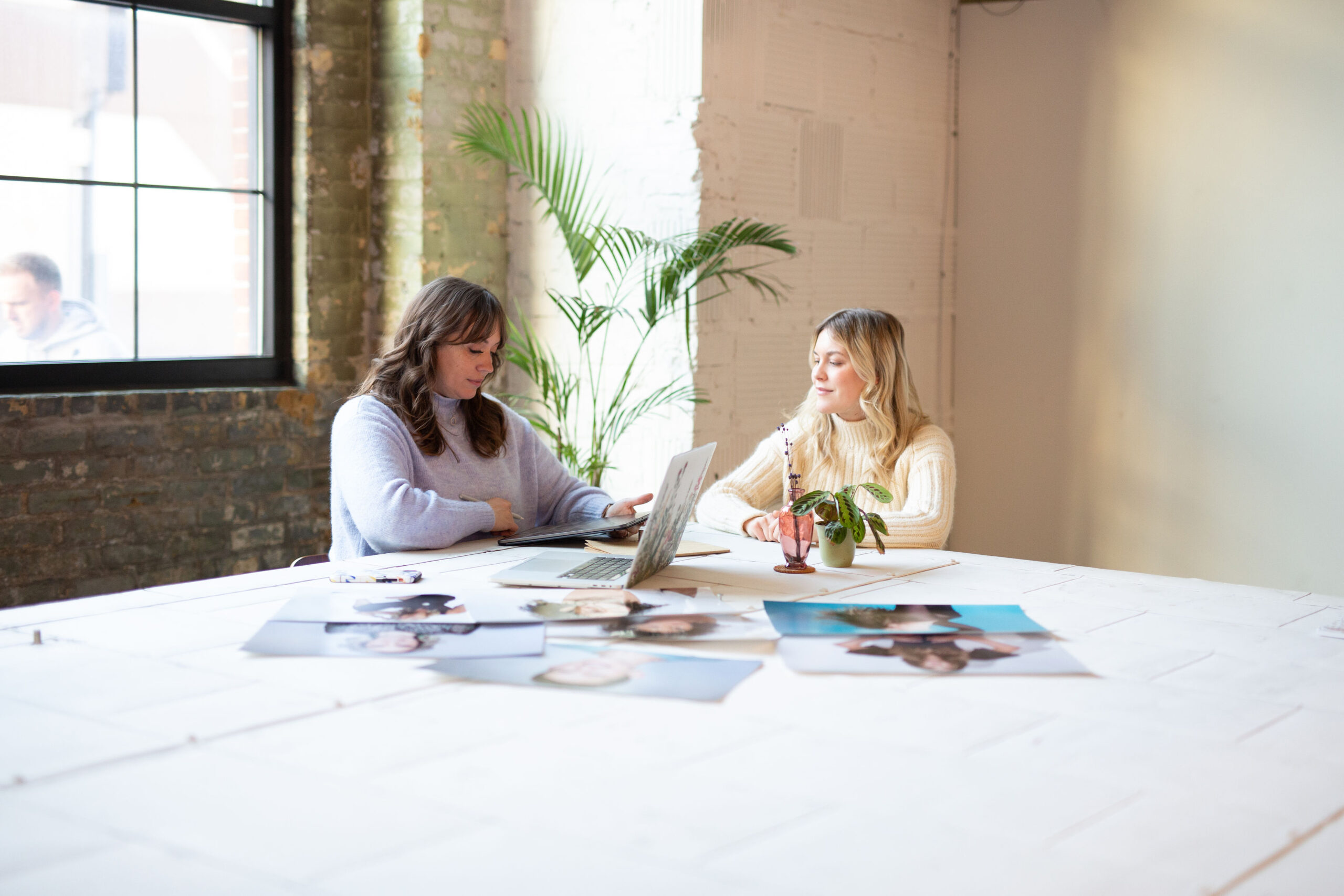 two female photographers reviewing their work in an office space