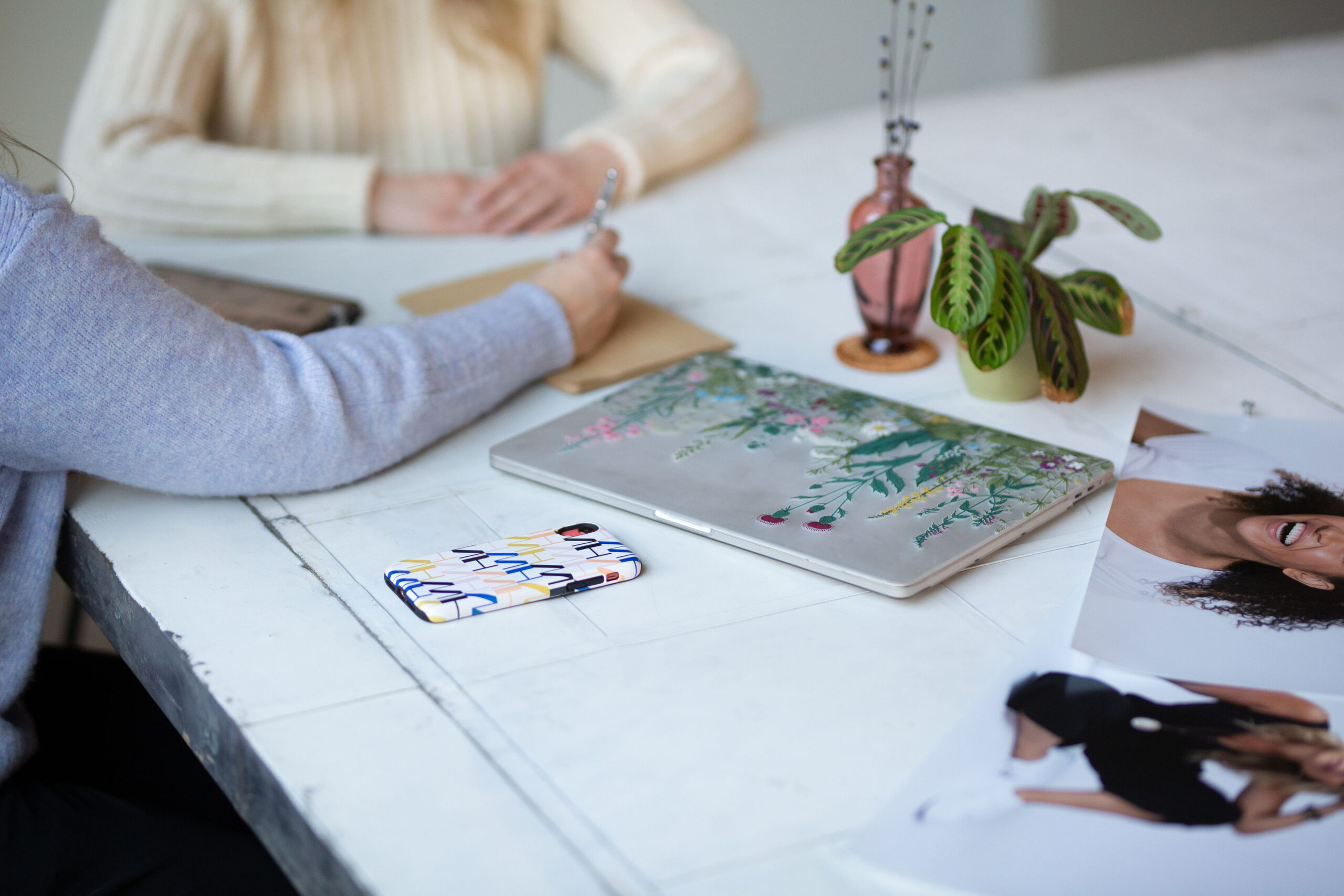 two women at a desk with one woman taking notes 