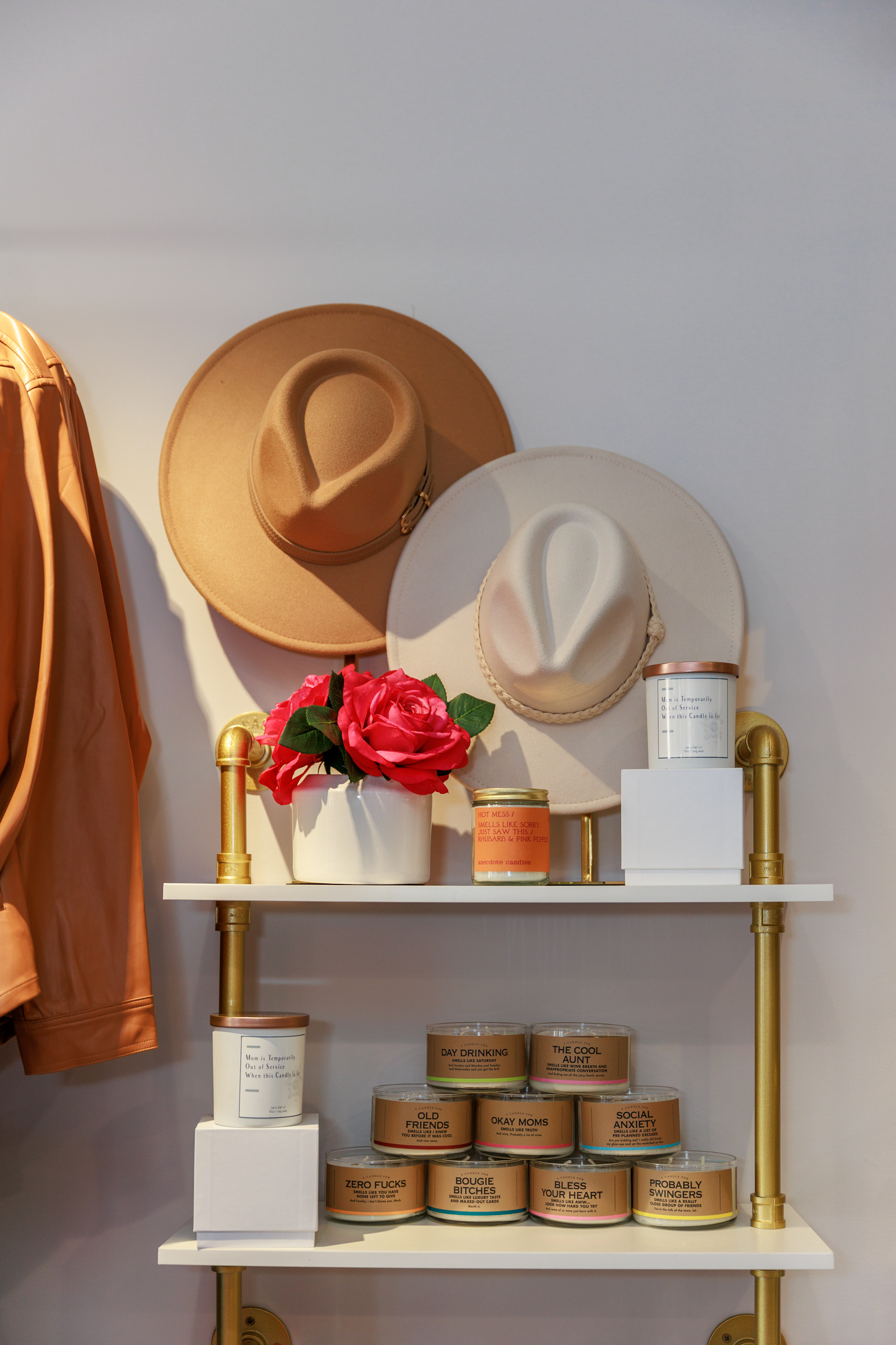 candles and hats on display on a shelf 