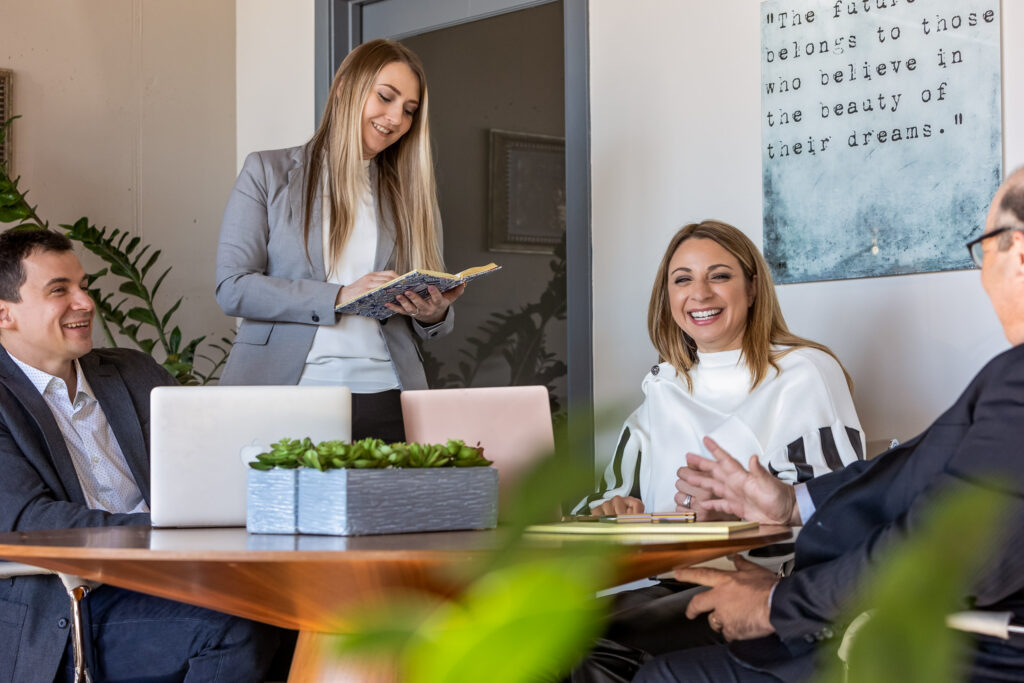 A group of coworkers laughing around a table 