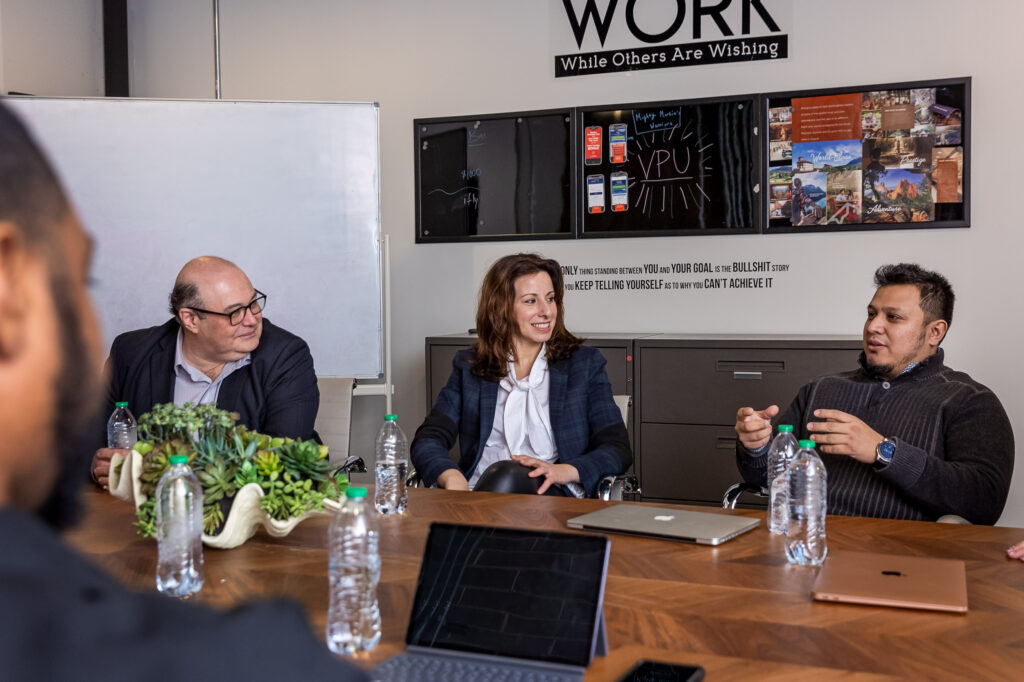 A group of people during a meeting at work around a table 
