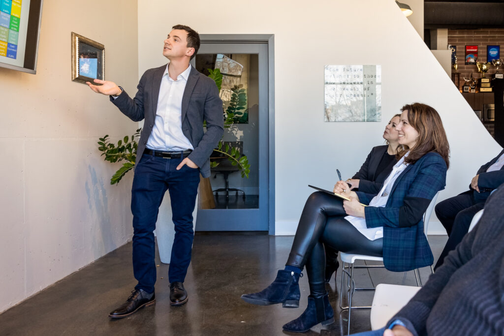 A person giving a presentation in front of a room of people 
