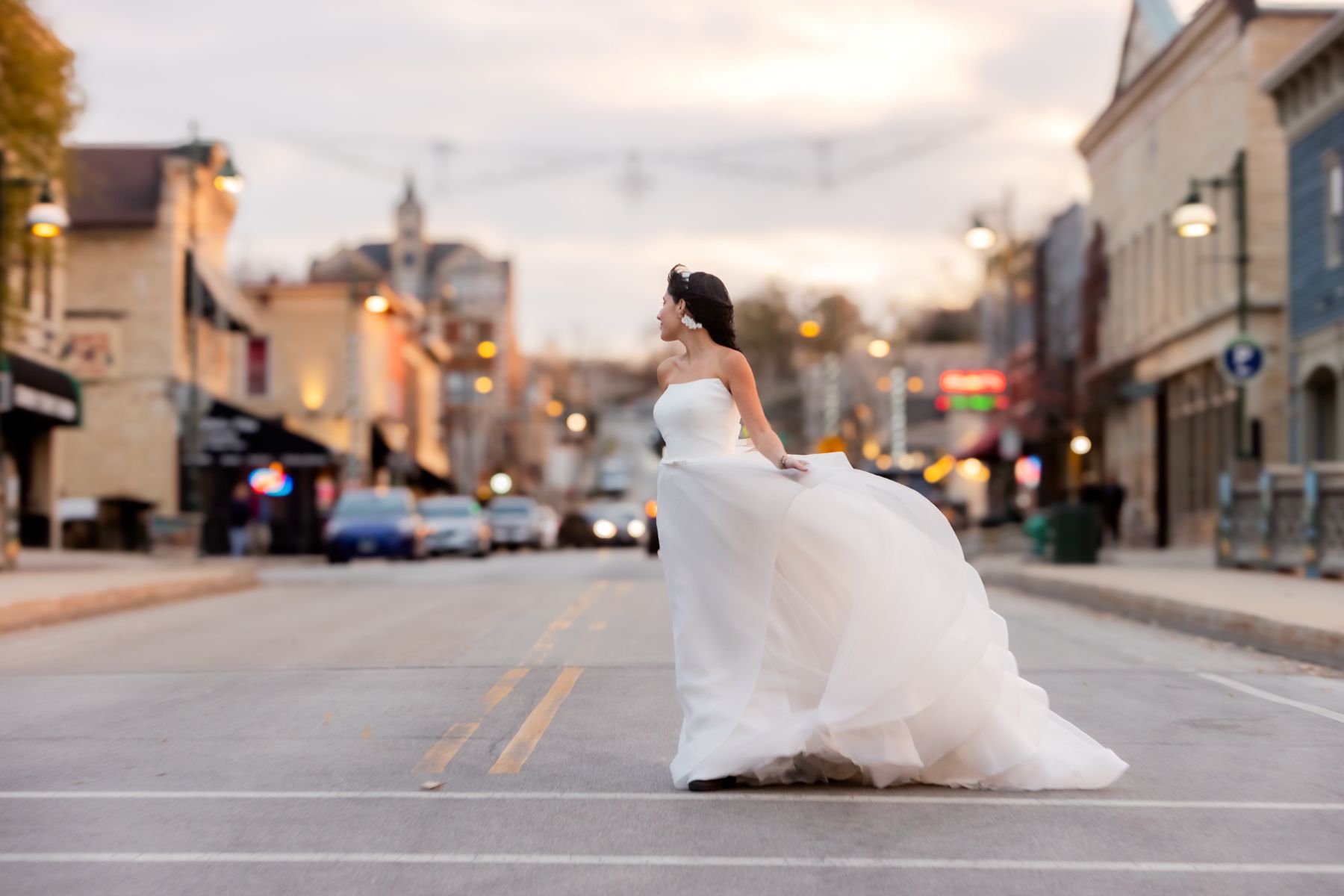 commercial brand photography for Martellen's Bridal in lemont illinois a woman is waering a white wedding dress on main street and crossing the street 