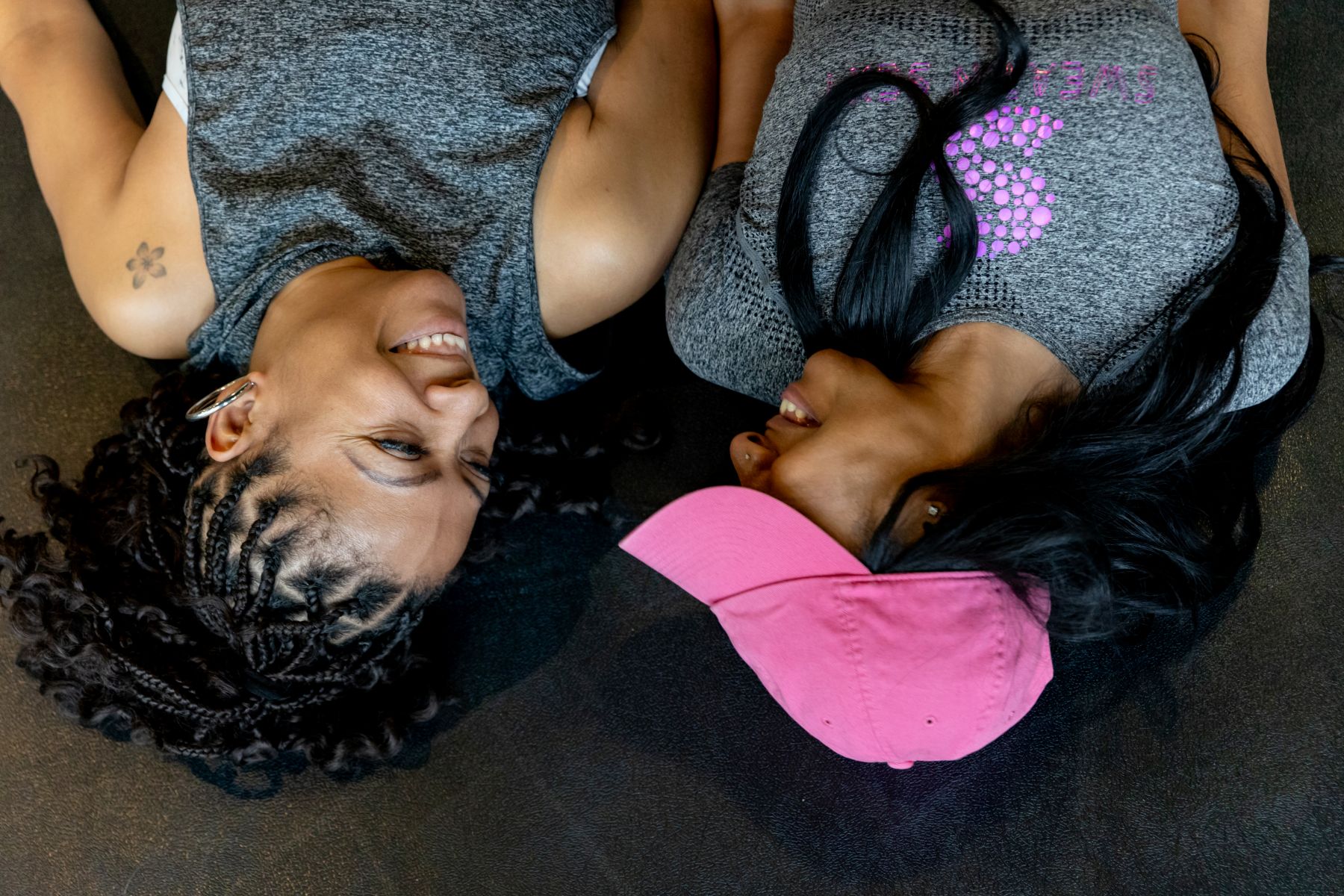 two women at sweatin sexy in lemont illinois laying on the floor and looking at each other and smiling 